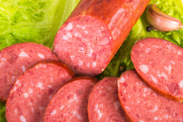 Salami with lettuce, pepper and garlic on a white background