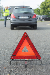 warning triangle behind stalled car