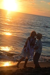 Mädchen und Junge unterhalten sich beim Sonnenuntergang am Strand