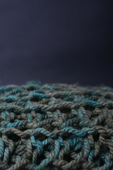 Large binding needles. Wool knitted fabric. Wool textiles. Crochet. Scarf. Background.