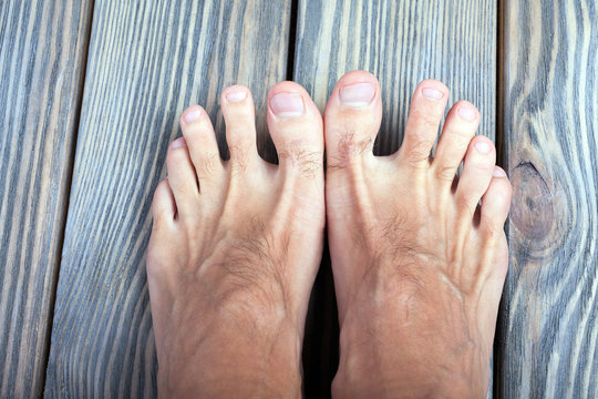 male feet on wooden background.