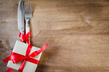 Cutlery Decorated with Red Ribbon on Wooden Background.
