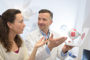 Doctor showing model of the eye to patient