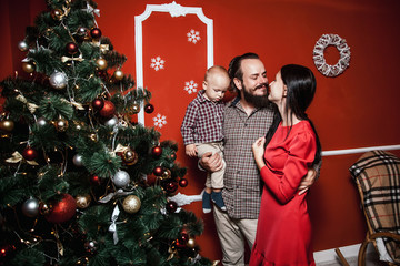 Christmas family portrait in home holiday living room, baby with parents, decorating house with...