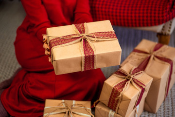 Woman with Christmas gifts in home interior, close up