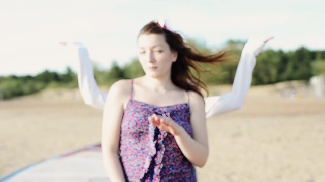 Two young girls and man dance on beach smile in camera. Sunny day. Vacation. Holidays