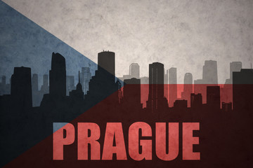 abstract silhouette of the city with text Prague at the vintage czech republic flag