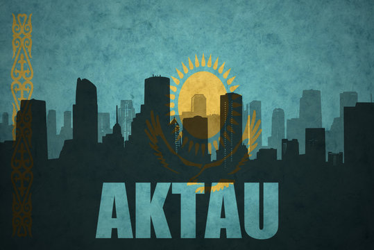 abstract silhouette of the city with text Aktau at the vintage kazakhstan flag