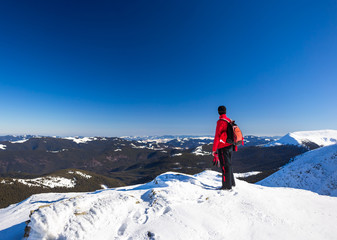 Young happy traveler hiking in beautiful mountains. Fantastic winter landscape