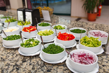 Salad bar with various sliced fresh vegetables