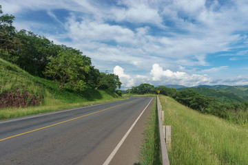 Fototapeta na wymiar road view with beautiful sky in green mountain, road trip travel concept