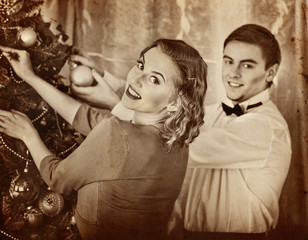 Couple on party decoration Christmas tree. Black and white retro.Old photo on yellow paper. - 127872278