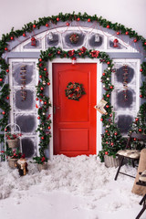 holiday decorated front entrance to home. Red door with Christmas wreath
