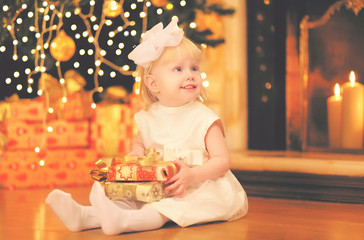 Obraz na płótnie Canvas Christmas happy child little girl with gift box near christmas t