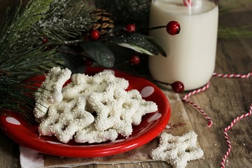 Snowflake pretzels with glass of milk on holiday background