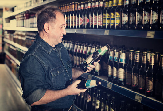 Pensioner Selecting A Beer At The  Store