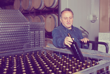 Smiling wine maker inspect containers
