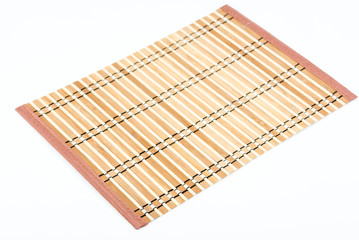 Traditional brown bamboo pad texture, rolled. Old Bamboo pad texture on white background. Sushi serving pad. Bamboo weave pattern. Mat for food serving. Closeup. 