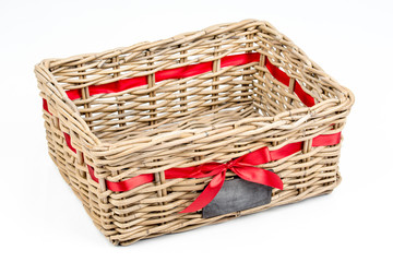 Woven rectangle box,basket with red satin ribbon (tape) and small blackboard. Vintage Christmas decoration box for Christmas and new year, isolated on the white background. Empty basket. Side view