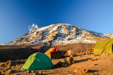 Fototapete Kilimandscharo Atemberaubende Abendansicht von Kibo mit Uhuru Peak (5895 m über dem Meeresspiegel, höchster Berg Afrikas) am Mount Kilimanjaro, Kilimanjaro National Park, gesehen vom Karanga Camp auf 3995 m über dem Meeresspiegel. Zelte im Vordergrund.