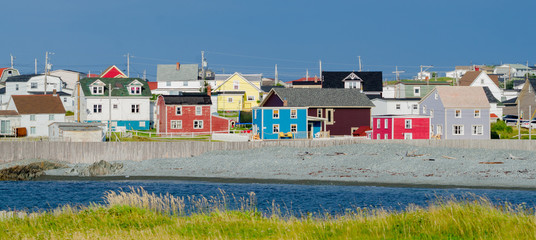 Small town with bright colored homes all over the coastal villages along the fingers of the Island of Newfoundland, Canada.  
