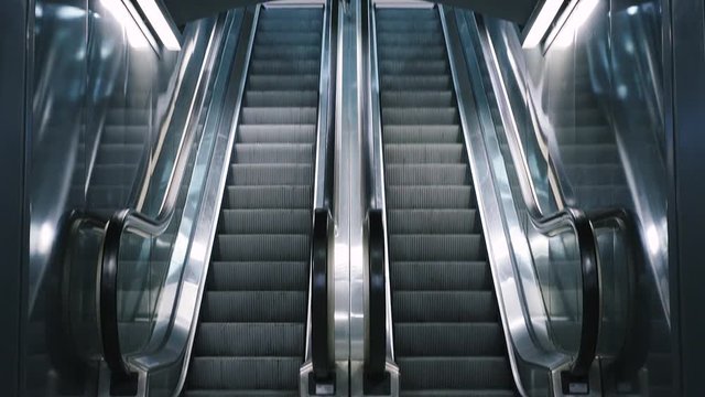 Close-up shot of empty moving staircase running up and down. Modern escalator stairs, which moves indoor.