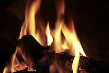 Flames of fire in a fireplace. Shooting horizontal with tones Orange and black.
