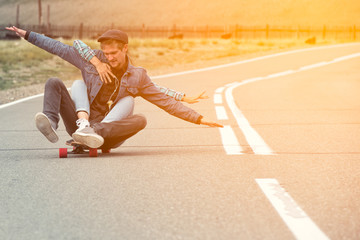 The guy with the girl drive to longboard on a mountain road. Woman hugging man. Their hands separated in different directions.