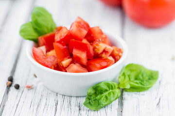 Tomatoes (diced) on wooden background (selective focus)