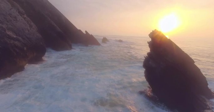 Amazing Aerial Shot Of Small Waves Hitting The Beach And Cliffs In Portugal. Flying Over Stormy Sea, Above The Splashes Of Water, Untouched, Powerful Nature.