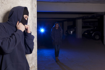 Criminal wearing a mask waiting for a woman
