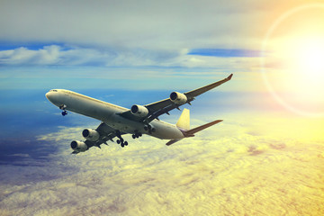 Fototapeta na wymiar air plane flying over cloud scape and sun light behind