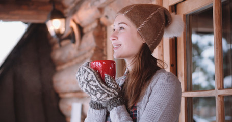 Woman with Cup of Hot Tea or Coffee Walks out the Cozy House on