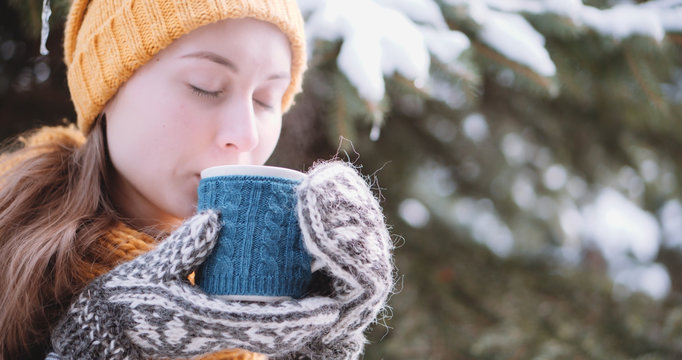 Woman Drinks Hot Tea or Coffee From a Cozy Cup on Snowy Winter M