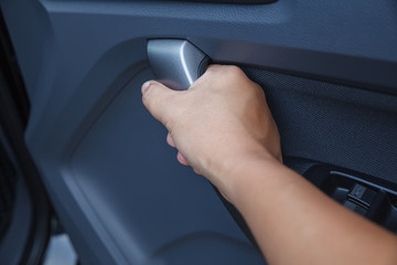 Man hand opens the inner door handle.