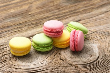 Different kinds of macaroons on wooden background