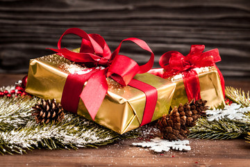 Fototapeta na wymiar gifts boxes with fir branches on wooden background close up