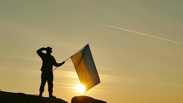 Soldier  salute Ukrainian Flag, sunrise time  in Slow Motion 