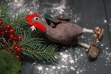 New Year 2017 symbol  - handmade rooster with fir branches and cranberry on wooden background