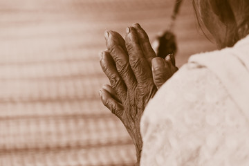 Hand of Old woman praying retro vintage tone