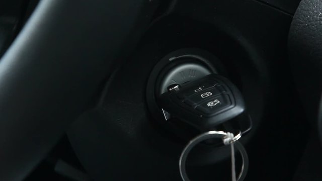 Man's hands turning the ignition key in the car