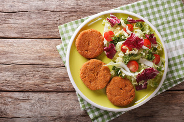 Dietary carrot cutlets and salad of chicory, cabbage and tomatoes close-up. horizontal top view