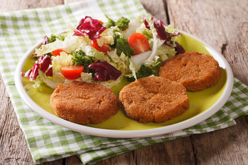 Dietary breakfast: carrot cutlets and salad of chicory, cabbage and tomatoes close-up. horizontal
