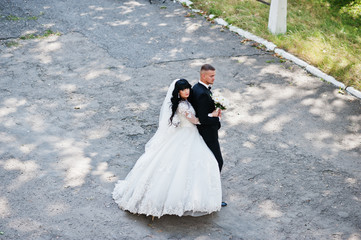 View from above of stylish wedding couple on road at park.