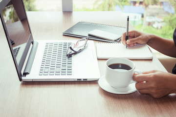 Close Up of woman hands using mobile phone and laptop computer with blank copy space screen for your advertising text message or content business in the Vintage effect.