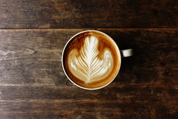 cup of latte art coffee on wooden background