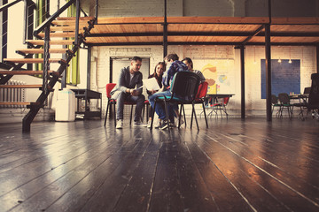 Creative business people meeting in circle of chairs.