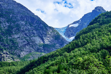 Fototapeta premium Folgefonna Glacier seen from the west side at Bondhussoen with green tree covered slopes in the foreground