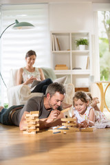 Cheerful family at home, Daddy playing with his daughter