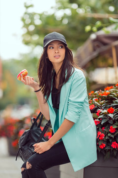 Young Asian Woman Eating Fast Food Outdoors